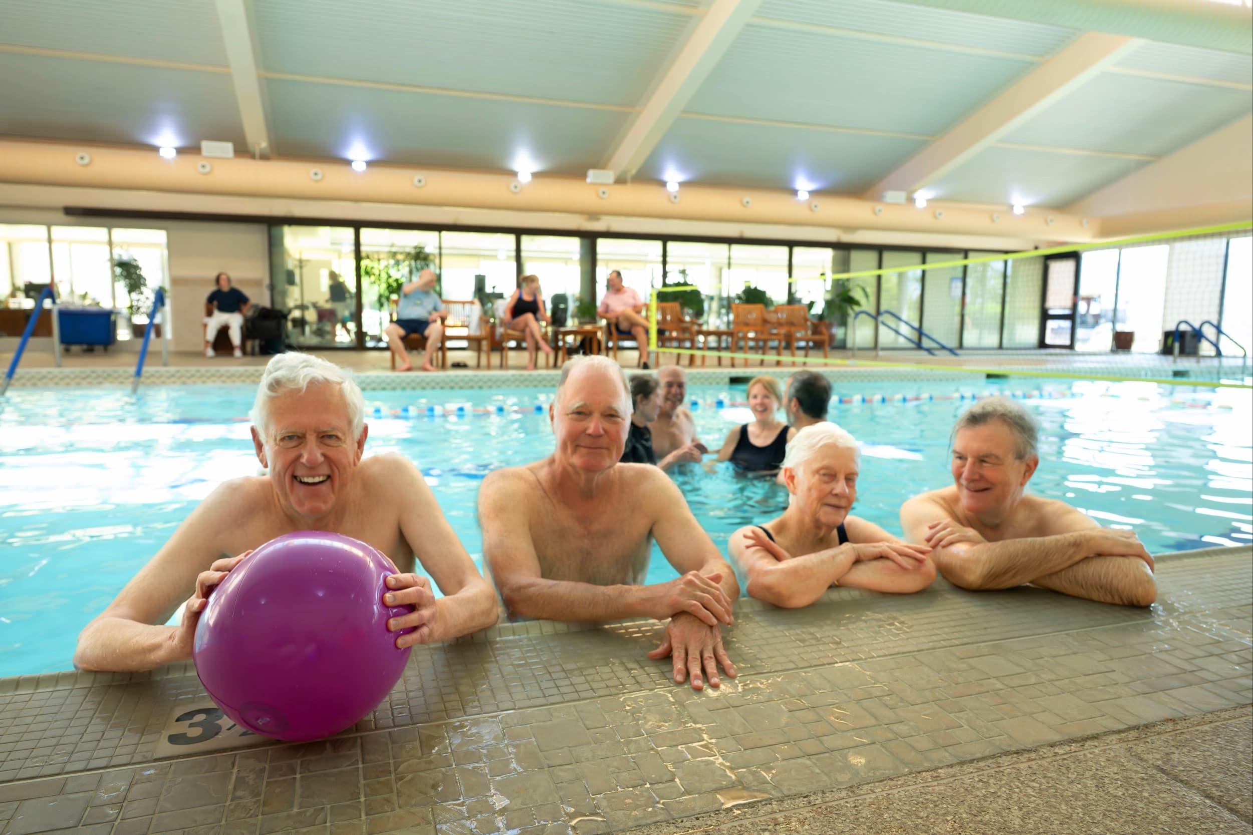 Four men laughing in the pool.